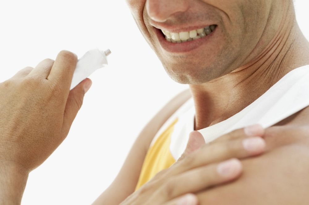 man rubbing topical pain relief on lotion